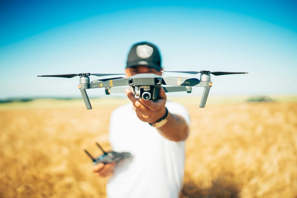 Drone held by person in wheat field.