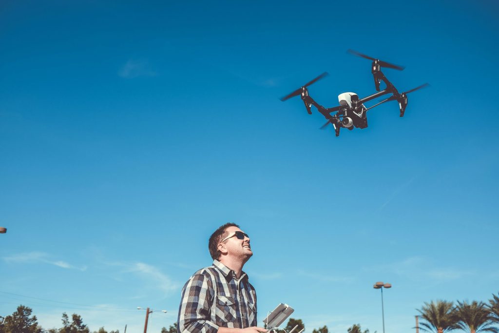 Man flying a drone in the sky.