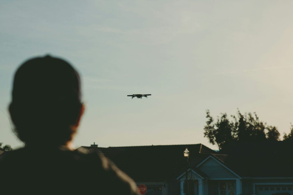 A person flying a drone by a house.