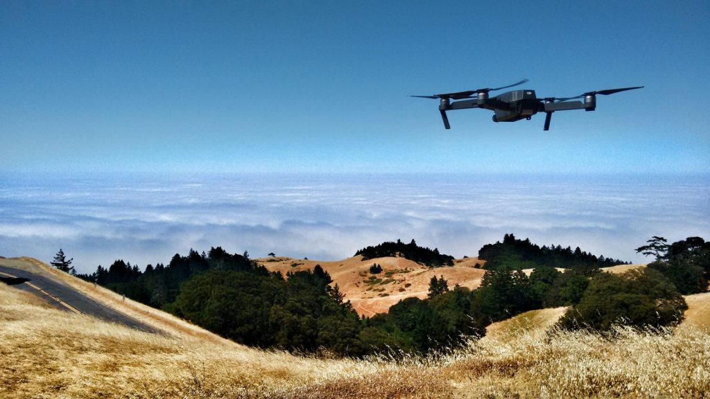 Drone hovering above while a hand reaches.