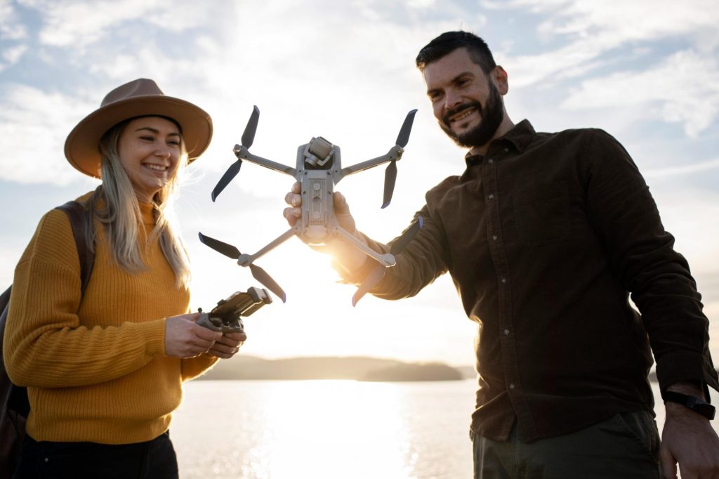 Couple holding a drone by the lake.