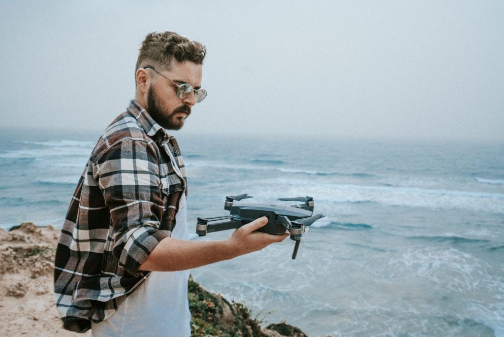 Man flying a drone in sunny sky